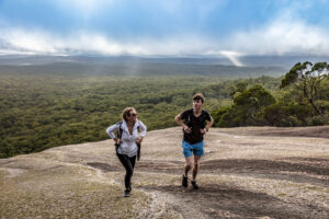 Two hikers crossing the bare granite dome towards the summit of Bald Rock