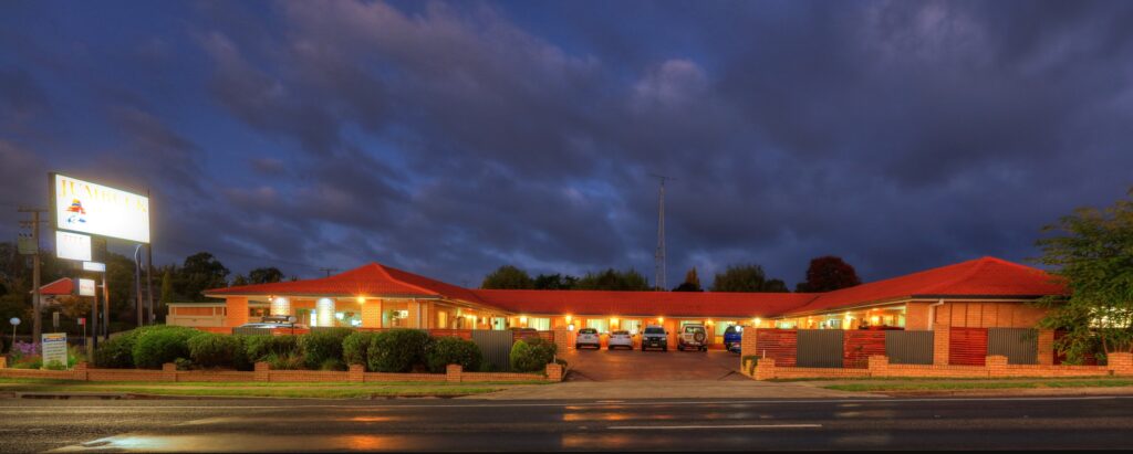 The Jumbuck Motor Inn lit up at dusk on the New England Highway, Tenterfield