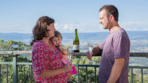 Family sharing sparkling wine at the Mount Mackenzie lookout rail