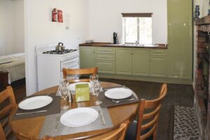 Cottage kitchen and dining table inside Four Bull Hut accommodation