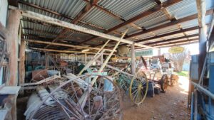 Historic wagons and farm equipment stored in a shed at Centenary Cottage Museum