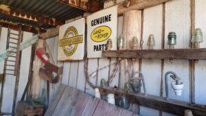 Shed wall hung with vintage lamps, tools and enamel signs at Centenary Cottage Museum