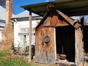 Rustic timber slab hut in the gardens at Centenary Cottage Museum
