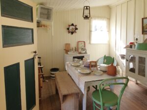 Restored early settler kitchen with table set for a meal at Centenary Cottage Museum