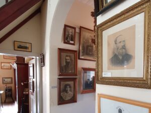 Framed portraits and historic photographs on display inside Centenary Cottage Museum
