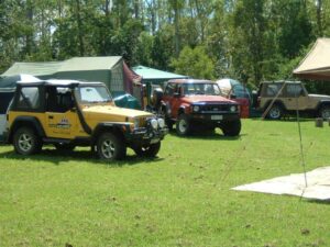 Four-wheel drive club vehicles gathered on the grass at Levuka