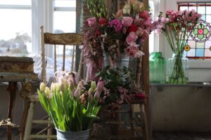 Antique chair with roses and tulips in buckets at White Cottage Flower Farm