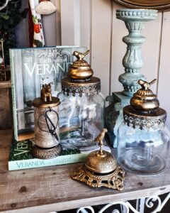 Green candlesticks, apothecary jars and brass bell at Ruben & Flax