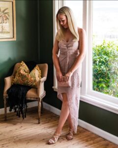 Model in a blush lace dress by a sunlit window, Sherelle Fashions