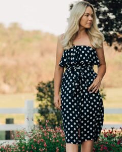 Woman modelling a black polka dot summer dress from Sherelle Fashions