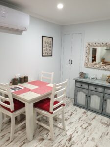 Dining room with white table and mirror inside Behind The Hedge B&B