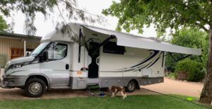 Motorhome parked on the lawn under trees at Behind The Hedge