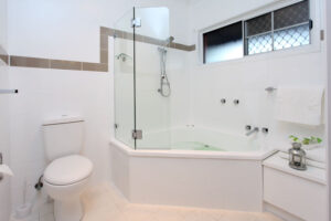 Corner spa bath and shower in a Henry Parkes Motel bathroom