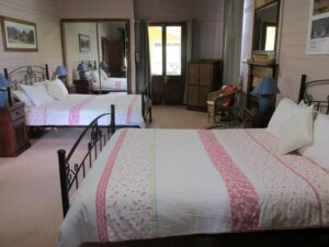 Bedroom with two beds and pink quilted covers at Henry's Cottage Tenterfield