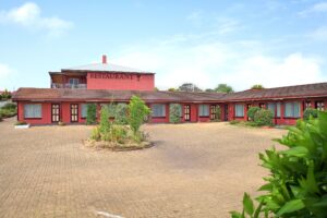 Red-roofed buildings and courtyard of The Henry Parkes Motel