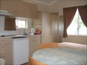 Kitchenette and dining table inside a cabin at Glenlyon Dam Tourist Park