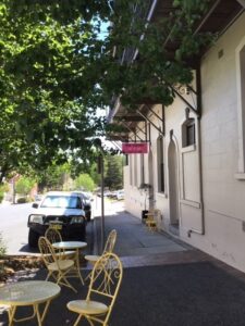 Footpath cafe tables under the shade trees outside The Corner Life & Style
