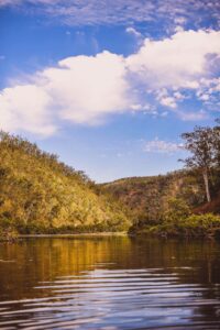 Calm waterhole on the Clarence River bordered by autumn-toned bushland