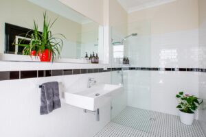 White-tiled bathroom with twin basins at The Commercial Boutique Hotel