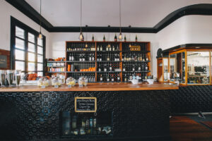 Black-tiled bar stocked with local wine and spirits at The Commercial Boutique Hotel