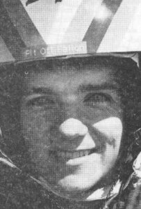 Black and white portrait of Flight Lieutenant Mark Fallon in flight helmet