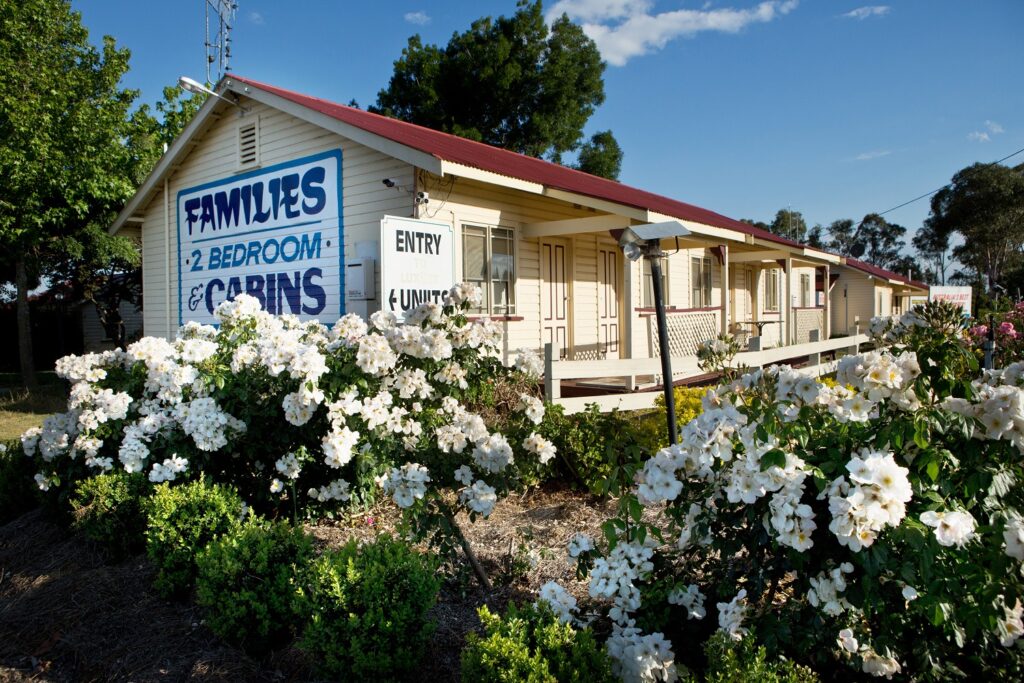 The Golfers Inn cabins behind flowering white rose gardens