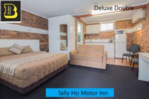 Deluxe double room with sofa and kitchenette at the Tally Ho Motor Inn