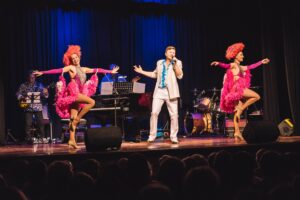 Cabaret performers in pink feathers on stage at the Tenterfield Cinema and Theatre