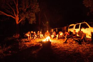 Group gathered around a blazing campfire at night at Cullendore High Country