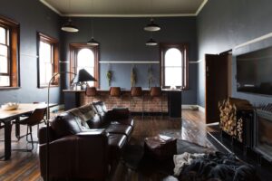 Lounge with fireplace, leather seating and dark feature walls at the Old Council Chambers