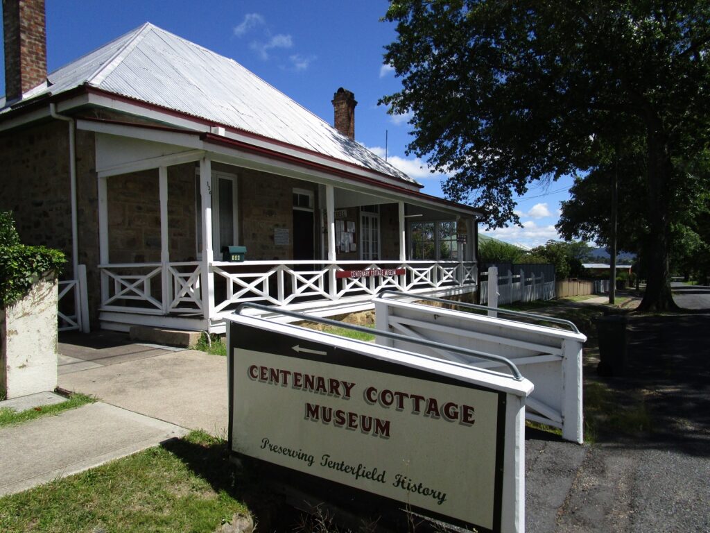Centenary Cottage Museum entrance sign and stone cottage in Tenterfield