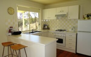 Modern white kitchen with island bench at Mistral Hill Country Cottage