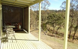 Covered verandah with outdoor seating overlooking the hills at Mistral Hill