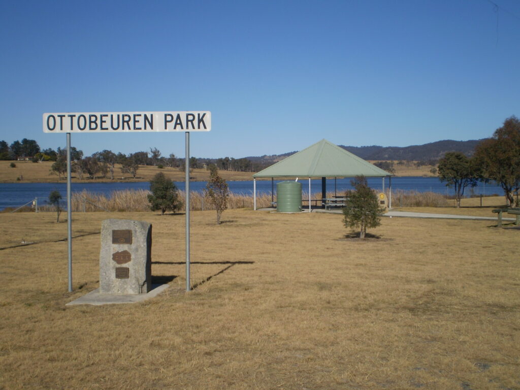 Ottobeuren Park sign and picnic shelter beside the dam