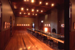 Original theatre hall with timber floor and exhibition tables at the School of Arts