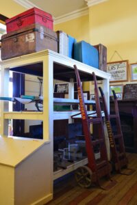 Museum shelves of vintage luggage, trolleys and railway ladders at Tenterfield Railway Museum