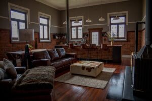 Open-plan lounge with leather sofas and polished timber floors at the Old Council Chambers