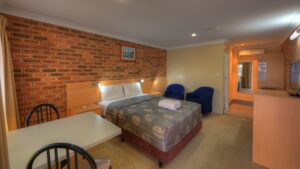 Motel room with queen bed and dining table at the Jumbuck Motor Inn