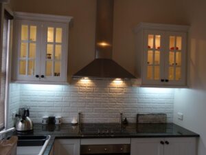 Under-cabinet lighting over the kitchen bench in Red Rose Cottage
