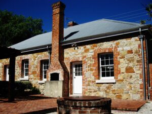 Red Rose Cottage, a stone cottage with brick chimney and paved courtyard