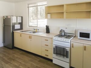 Kitchen with fridge, stove and microwave inside Robinsons Cabin