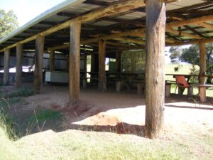 Timber-pole shelter shed with tables at Lanikai Camping Ground