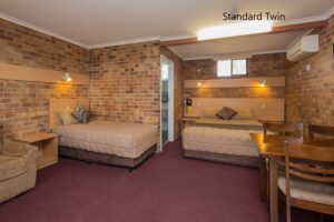 Standard twin room with brick feature wall at the Tally Ho Motor Inn