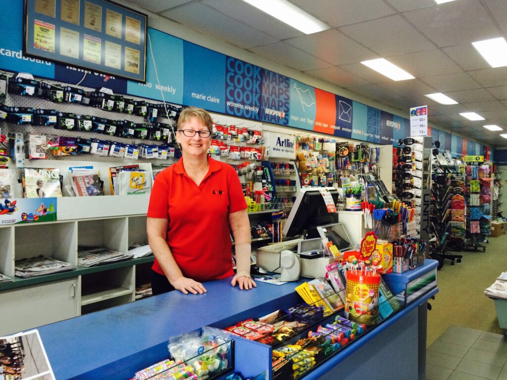 Friendly staff member at the counter of Sullivans Newsagency, Tenterfield