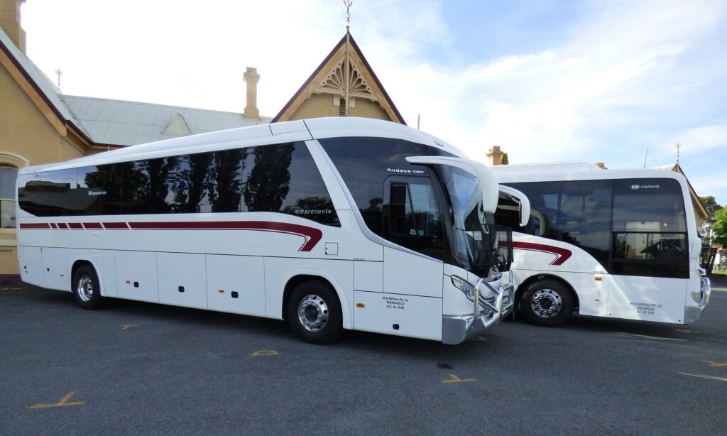 Two Tenterfield Coaches touring buses parked beside the heritage station