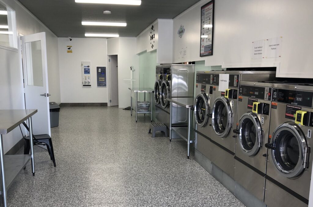 Rows of commercial washers and dryers at the Tenterfield Laundrette