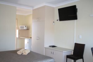 Motel room with queen bed, TV and kitchenette at the Tenterfield Motor Inn