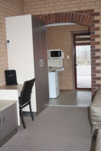 Room entry with kitchenette and desk at the Tenterfield Motor Inn