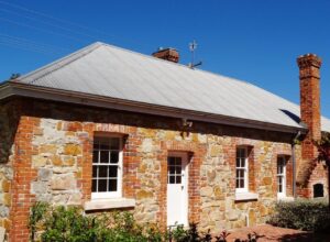 Historic stone cottage with brick chimney, White & Red Rose Cottages Tenterfield