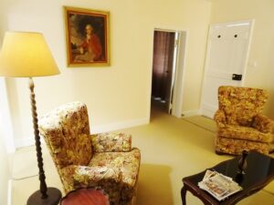 Lounge room with lamp and armchairs at White & Red Rose Cottages